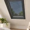 Plissee-Insektenschutz mit weißem Profil an einem Dachfenster im Schlafzimmer
